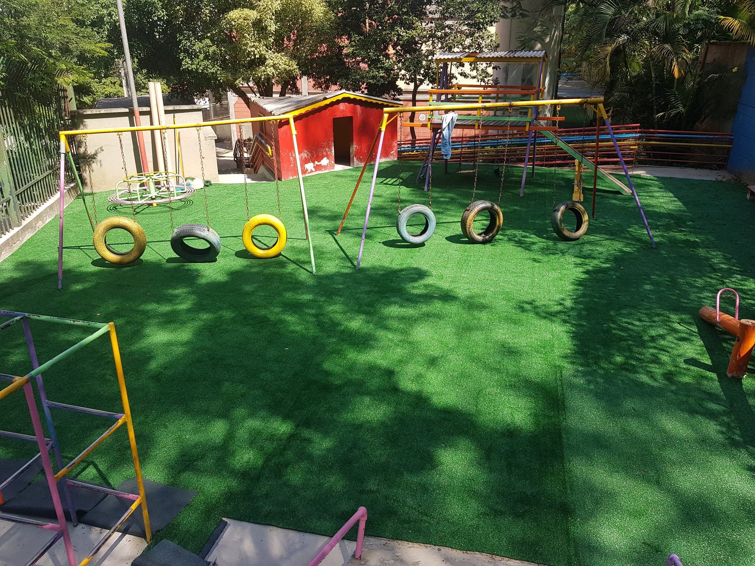 Grama sintética instalada em playground com balanços
