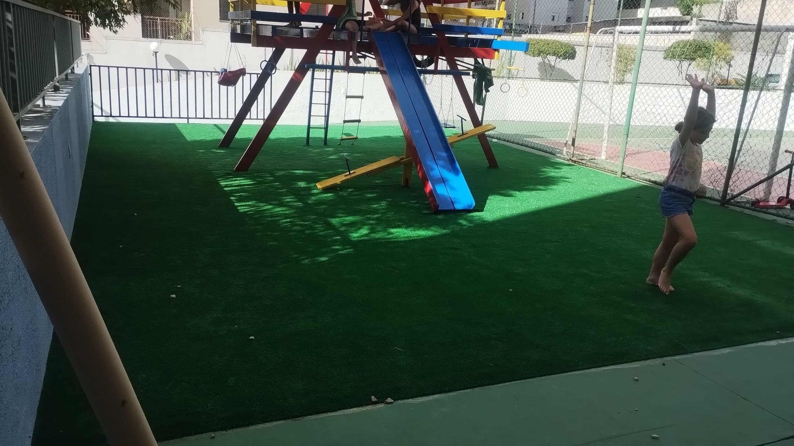 Criança brincando sobre grama sintética instalada