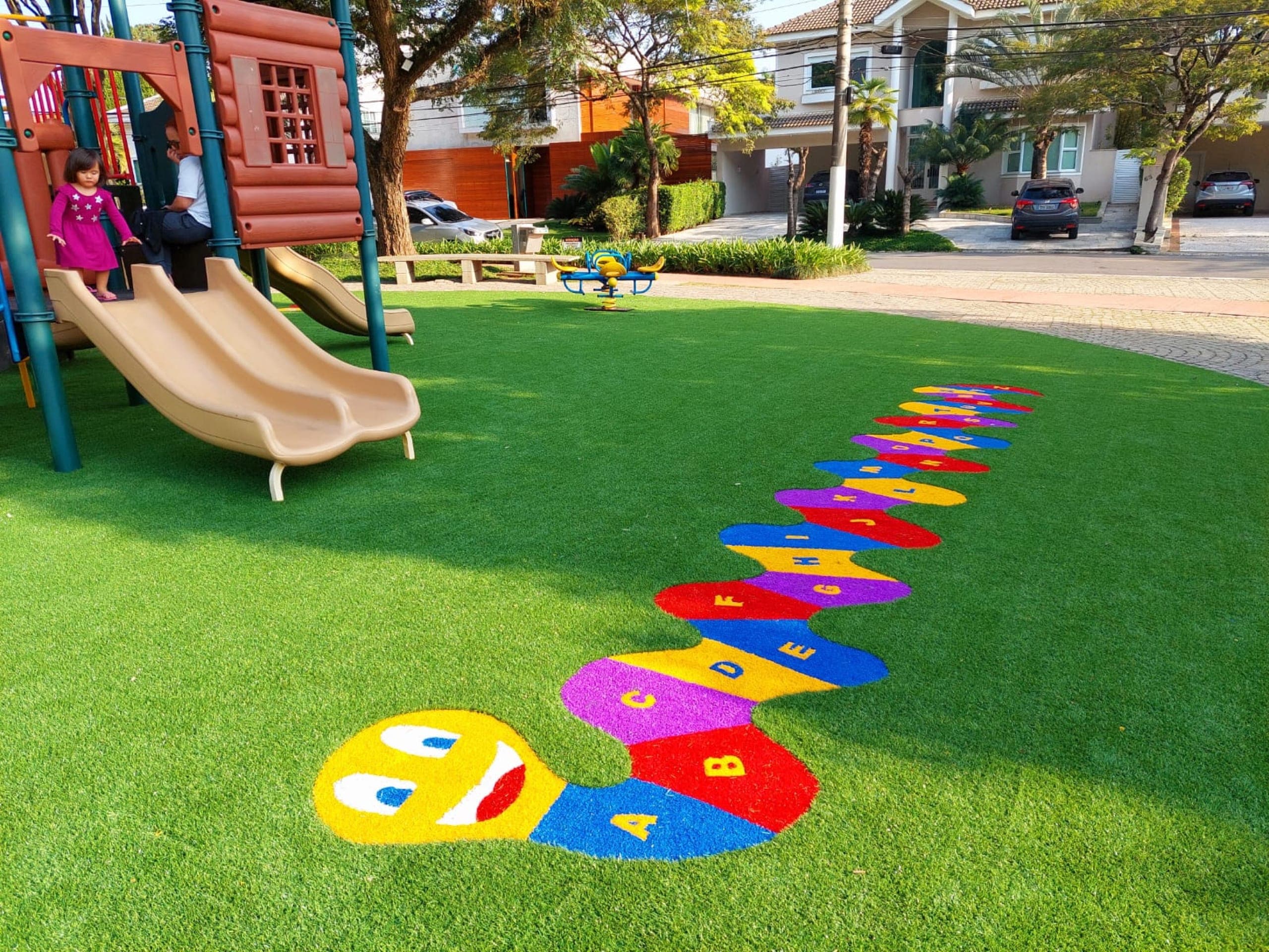 Playground com grama sintética decorativa e desenhos coloridos